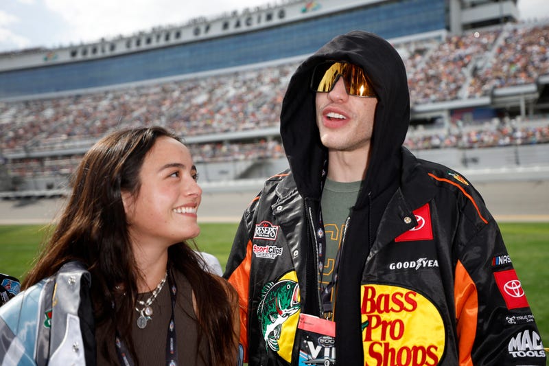 Pete Davidson and girlfriend Chase Sui talk on the grid prior to the NASCAR Cup Series 65th Annual Daytona 500 at Daytona International Speedway on February 19, 2023 in Daytona Beach, Florida.