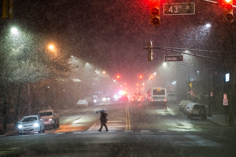A man covers himself of snow during a winter storm around Times Square on February 27, 2023 in Hoboken, New Jersey