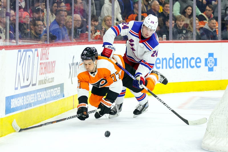 Tony DeAngelo, #77 of the Philadelphia Flyers, and Kaapo Kakko, #24 of the New York Rangers, challenge for the puck during the third period at Wells Fargo Center on March 1, 2023, in Philadelphia, Pennsylvania. 