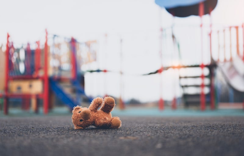 Teddy bear on ground by play structure
