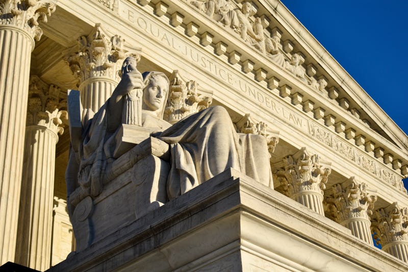 Contemplation of justice statue outside the Supreme Court