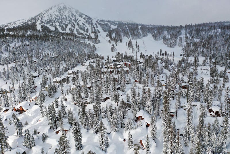 In an aerial view, snow from new and past storms blankets houses and condominiums near Mammoth Mountain chair lifts in the Sierra Nevada mountains, in the wake of an atmospheric river event, on March 12, 2023 in Mammoth Lakes, California.