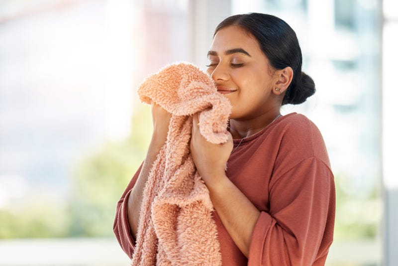 Woman smelling a piece of laundry. 