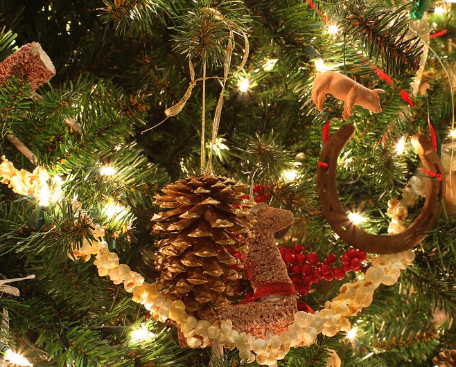 Christmas tree decorations up close, including a pinecone, pig, and horseshoe