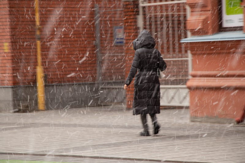 Woman walking in snow squall 