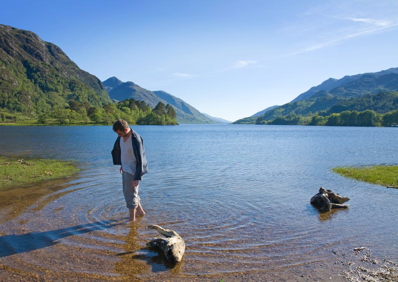 Man walking in rich waters of Loch Shiel, West Highlands