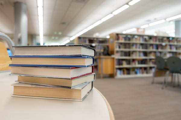 Stacks of books on a table in a library