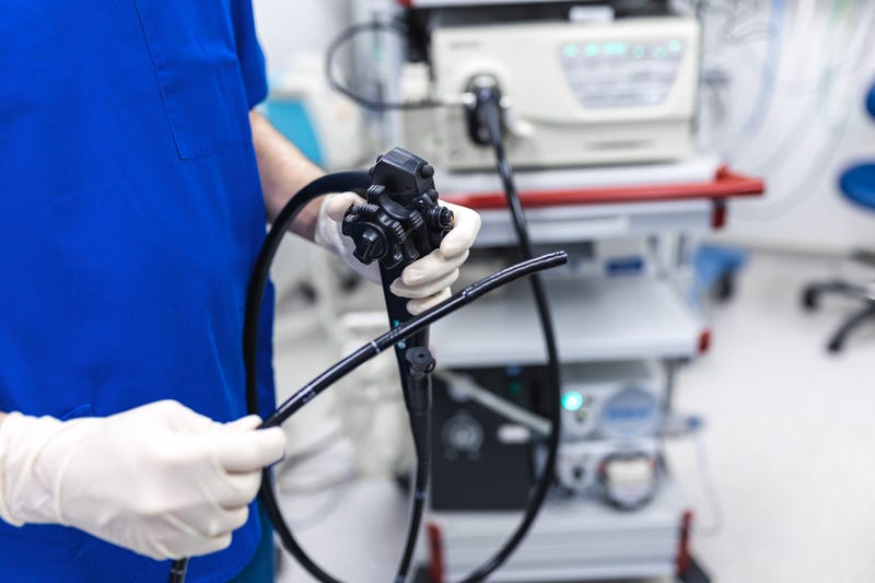 Proctologist holding endoscope during colonoscopy.