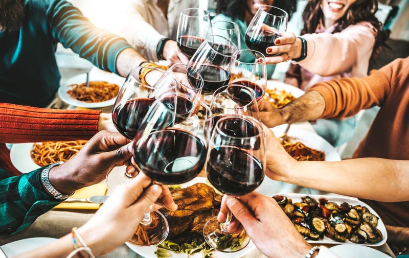 Happy friends toasting red wine glasses at dinner party - Group of people having lunch break at bar restaurant - Life style concept with guys and girls hanging out together - Food and beverage - stock photo