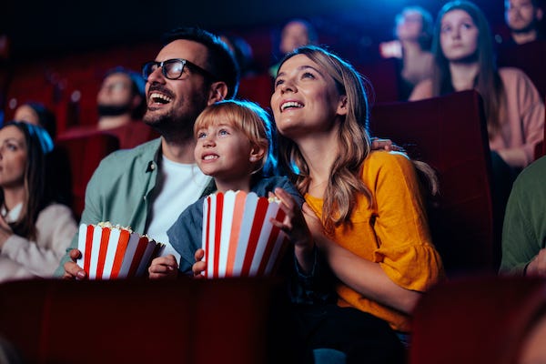 Happy family watching a movie in the theater
