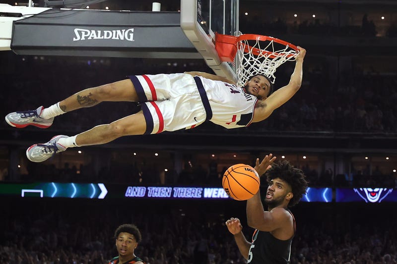 Andre Jackson Jr. of UConn hangs on to the rim after dunking the ball during the second half against the Miami Hurricanes during the NCAA Men's Basketball Tournament Final Four semifinal game on April 01, 2023 in Houston.