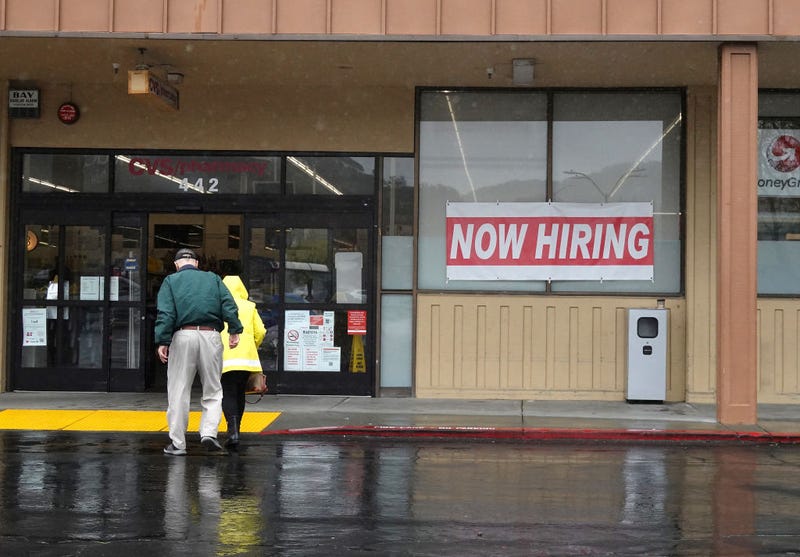 People walk by a now hiring sign posted in front of a CVS store on April 07, 2023 in San Rafael, California. The U.S. labor market added 236,000 jobs in March bringing the national unemployment rate down to 3.5 percent.