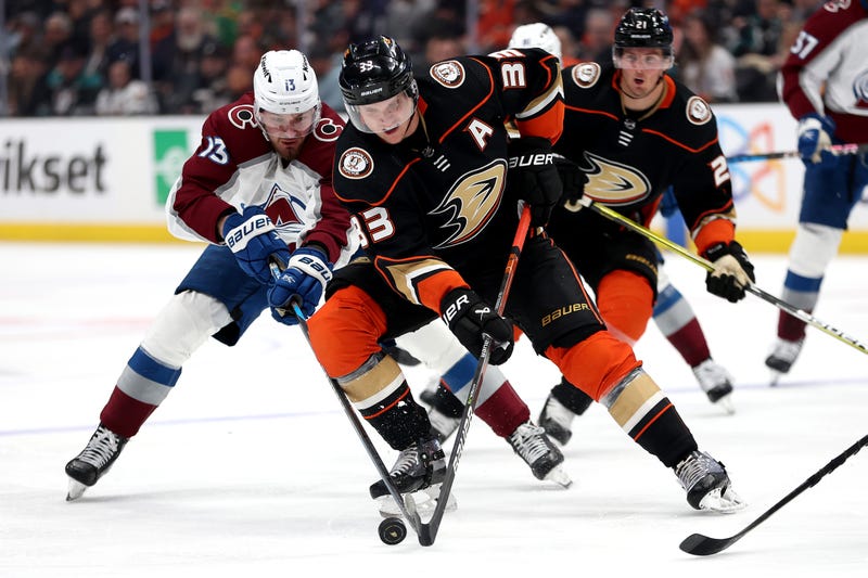 hockey players go after puck