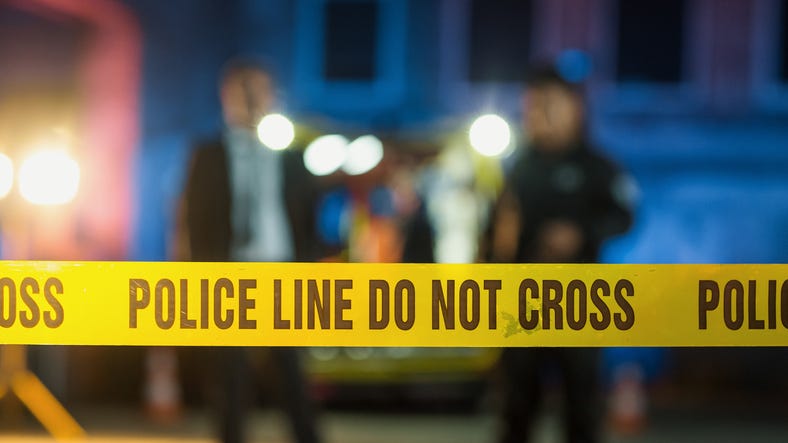 Do-not-Cross Tapes Restricting Access to Crime Scene in a Back Alley. Detectives Inspecting the Body and Thinking About the Murderer's Motive.