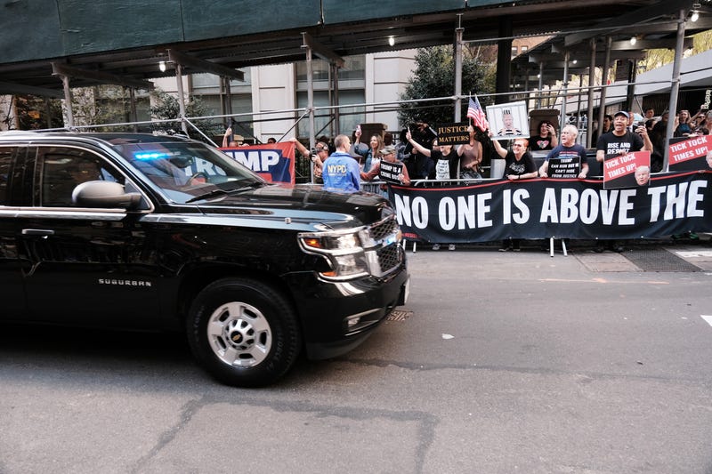 Trump's motorcade passes protesters and supporters on the way to the attorney general's office in Lower Manhattan on April 13, 2023