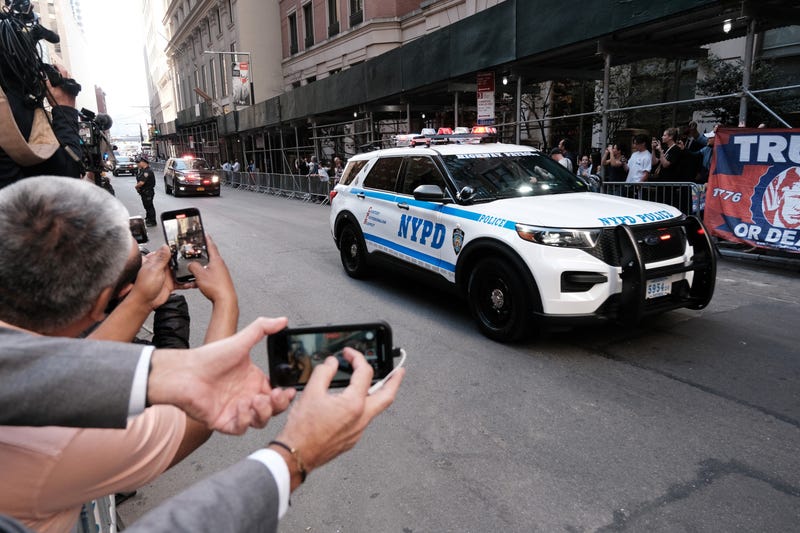 Donald Trump's motorcade drives by demonstrators as he arrives at the office of the New York attorney general on April 13, 2023