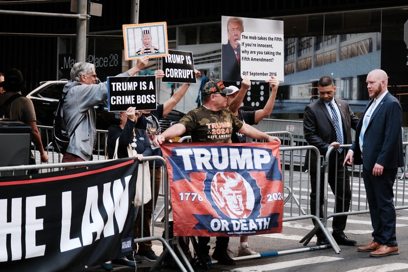 Anti-Trump and pro-Trump demonstrators greet the former president's motorcade in Lower Manhattan on April 13, 2023