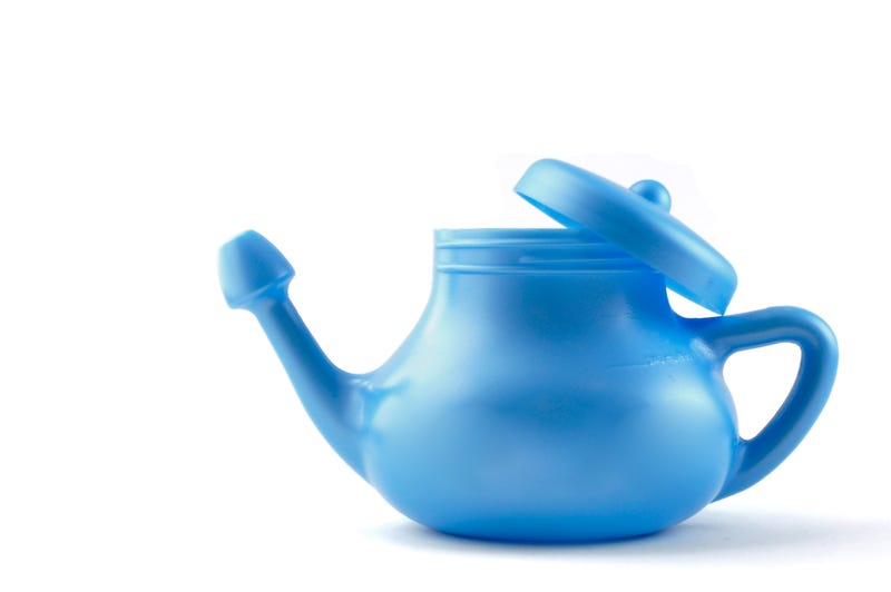 Sinus rinse stock photo. Blue neti pot against a white background.
