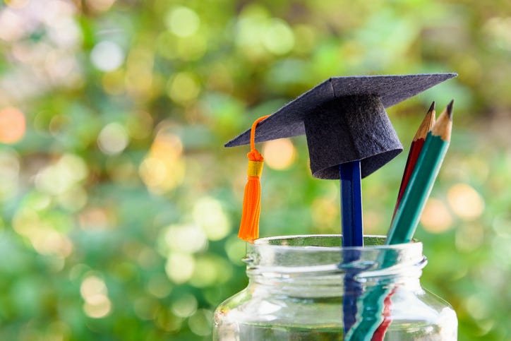 Black graduation cap and a pencil in a mason jar