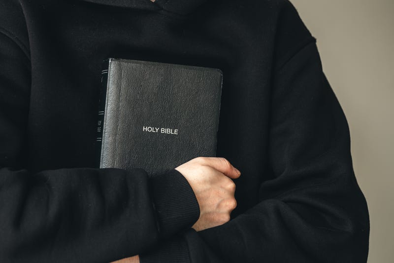 Priest holding Bible. 