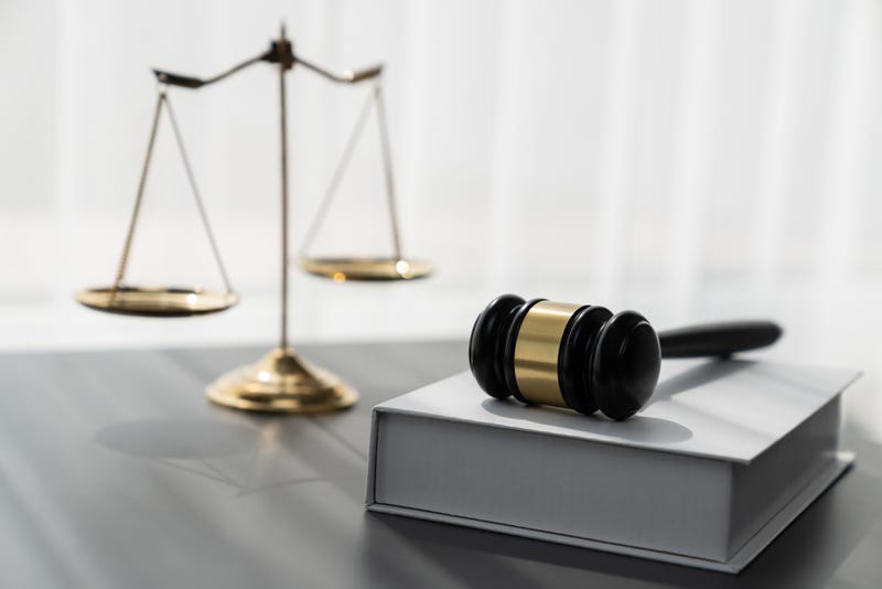 Symbolizing justice and legal authority, golden balanced scale and gavel on desk with law book in lawyer office background, reflecting concept of equality and fair judgment. equility