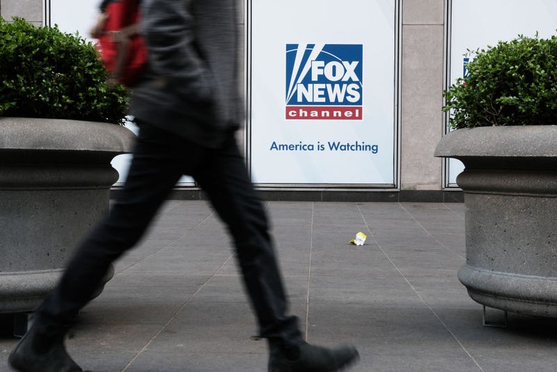People walk by the News Corporation headquarters, home to Fox News, on April 18, 2023 in New York City.
