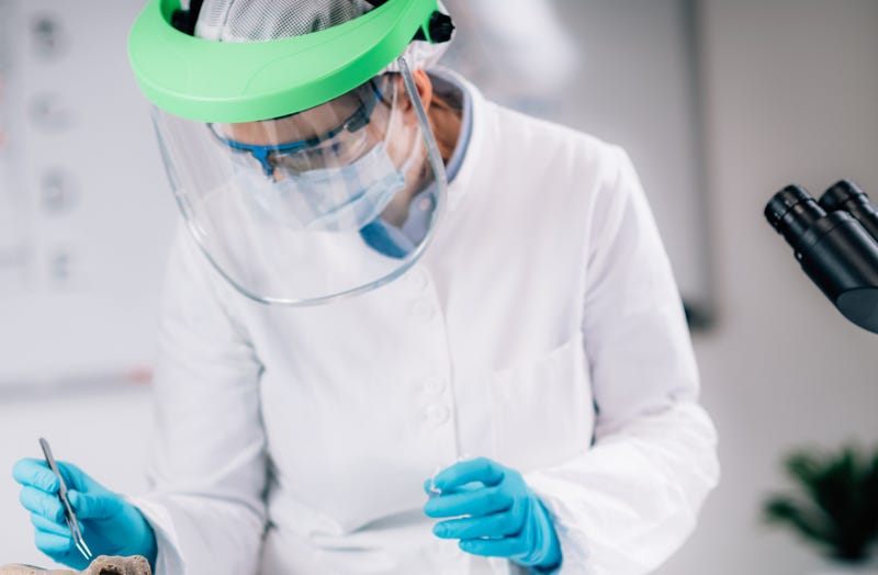 tech in white coat, rubber gloves