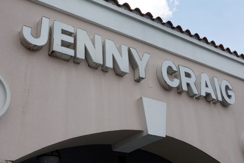 A Jenny Craig sign hangs on the wall outside of the weight loss store on April 28, 2023 in Miami, Florida. (Photo by Joe Raedle/Getty Images)