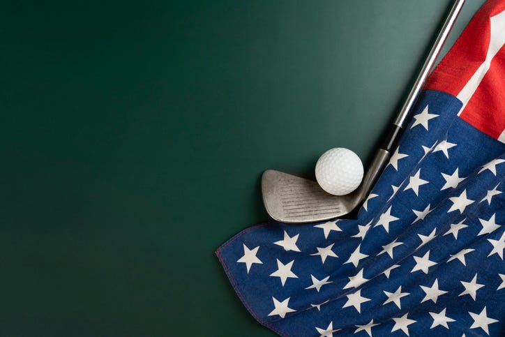 Golf ball and golf club with flag of USA on green table background