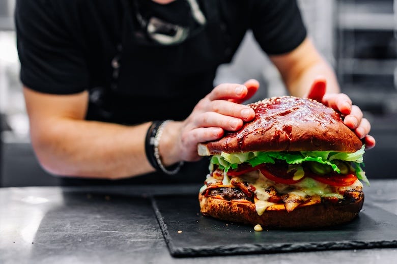 Chef preparing a large cheeseburger