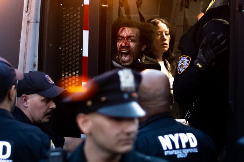 People are seen in an NYPD van during a vigil for Jordan Neely