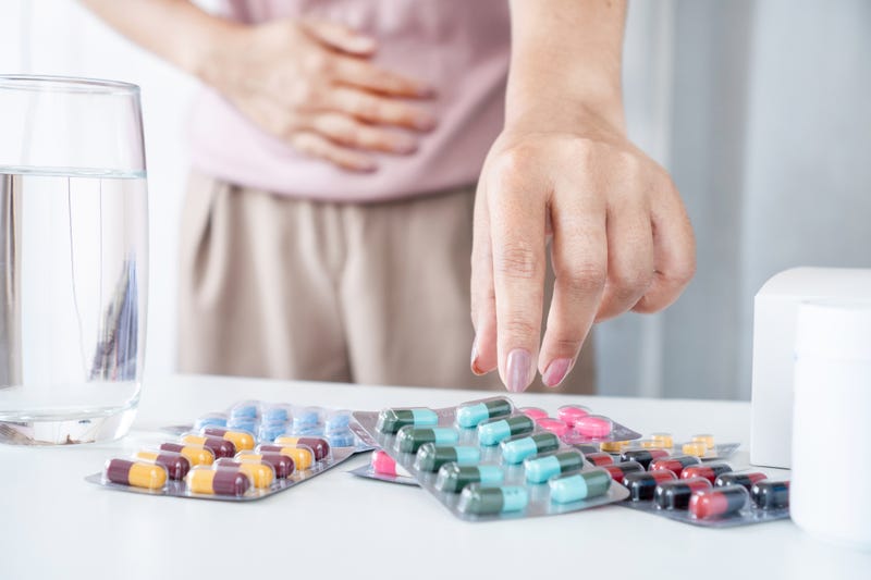 Woman grabbing for pills on a table. 