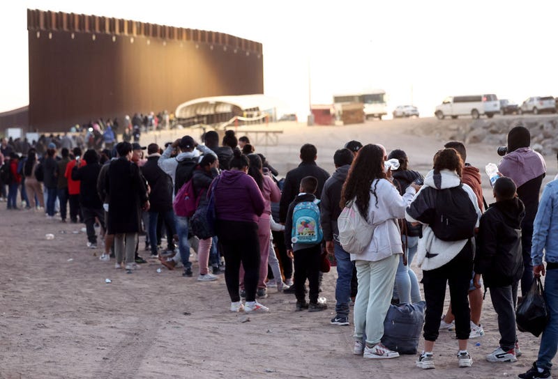 Immigrants seeking asylum in the United States wait in line to be processed by U.S. Border Patrol agents after crossing into Arizona from Mexico on May 11, 2023 in Yuma, Arizona. A surge of immigrants is expected with the end of the U.S. government's Covid-era Title 42 policy, which for the past three years has allowed for the quick expulsion of irregular migrants entering the country.