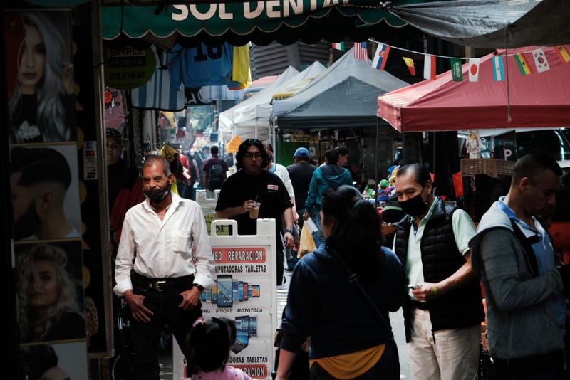 People walk along Roosevelt Avenue, which passes through the neighborhoods of Elmhurst, Corona and Jackson Heights on May 11, 2023 in Queens. 