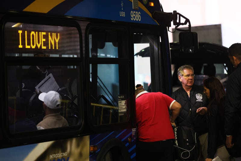 Asylum seekers board a bus en route to a shelter at Port Authority Bus Terminal on May 18, 2023, in New York City. 