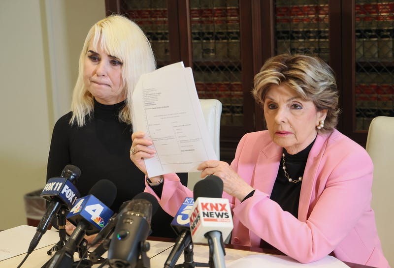 two women give press conference in front of microphones