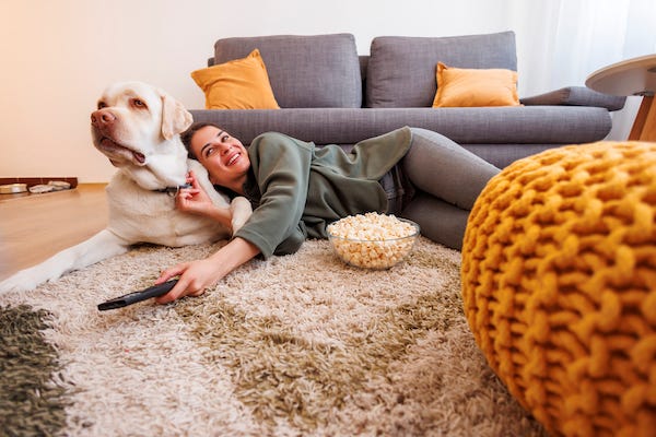Woman and dog watching tv at home