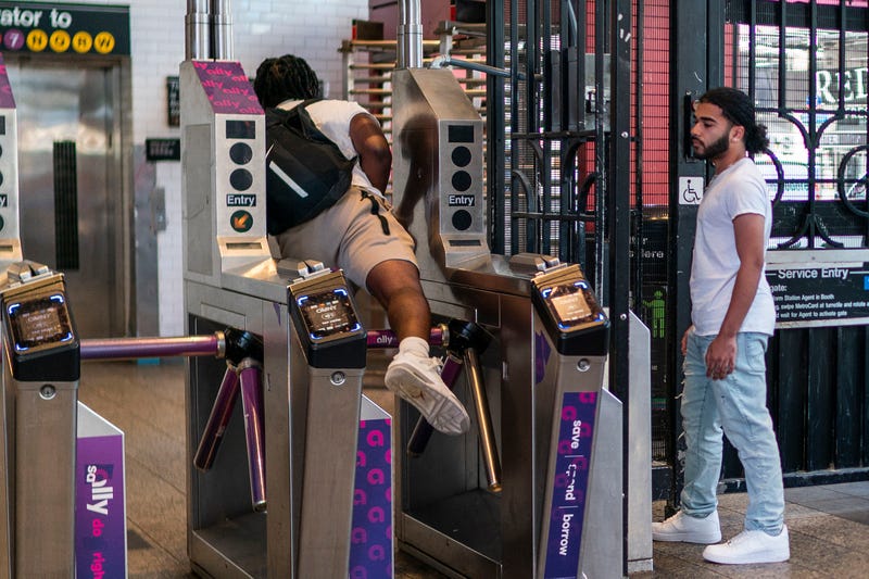 A man goes over a subway turnstile without paying the MTA fare at the Times Square station on June 5, 2023