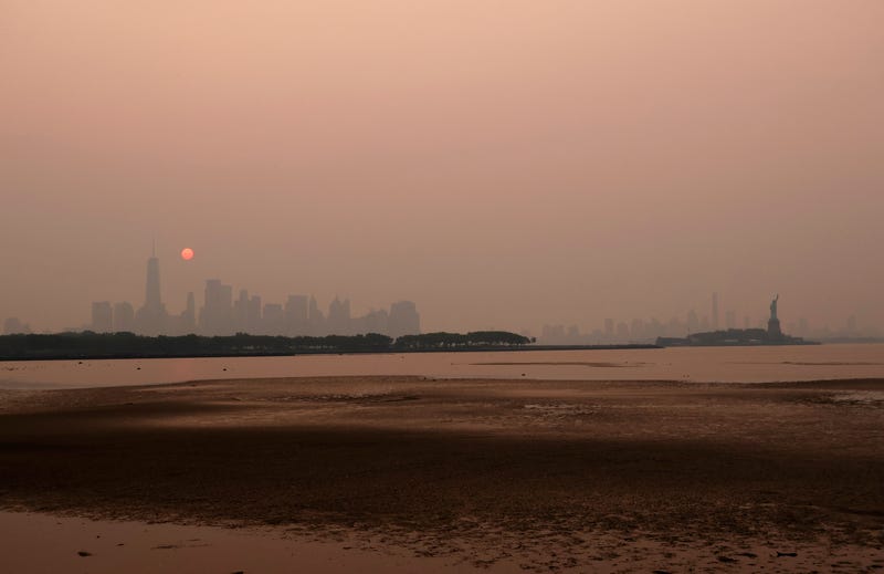 Smoke continues to shroud the sun as it rises behind the skyline of Lower Manhattan, Brooklyn and the Statue of Liberty in New York City on June 7, 2023