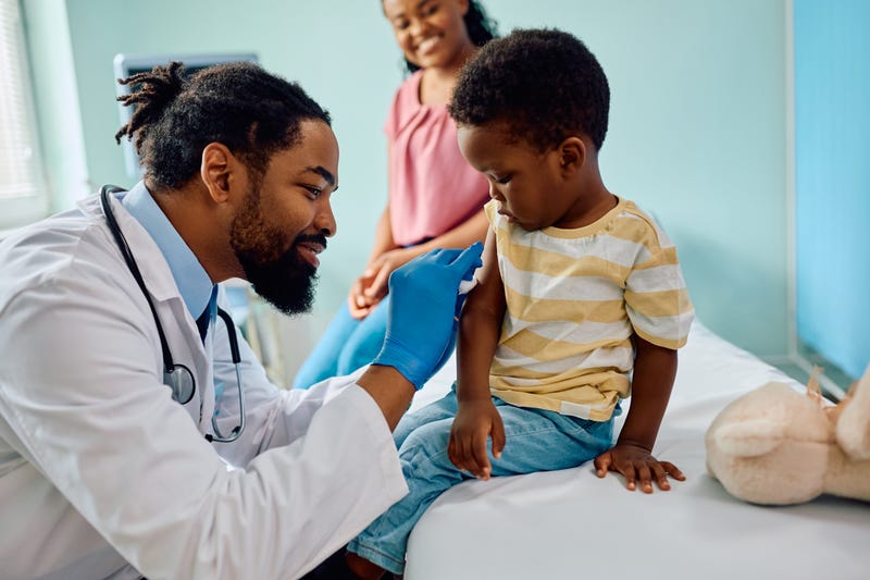 A pediatrician administers a vaccination to a small child.