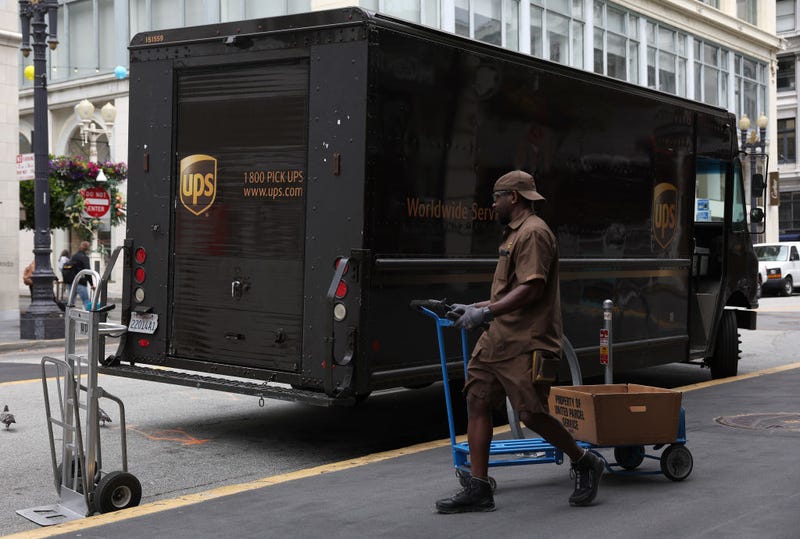 A UPS driver pulls a cart up to his truck while making deliveries on June 12, 2023 in San Francisco, California. 