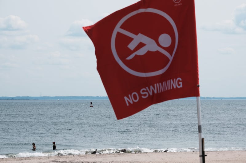 People swim along a stretch of beach without a lifeguard at Coney Island on June 15, 2023 in the Brooklyn borough of New York City. According to officials at NYC Department of Parks and Recreation, New York City only has about a third of the approximately 1,400 lifeguards needed to safely patrol swimmers this summer along New York's 14 miles of public beaches and numerous pools. Part of the reason stems from a dispute between city officials and the lifeguard union over the notoriously difficult swimming tests that weed out many applicants.