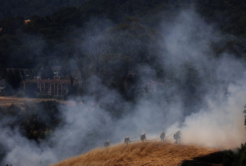 firefighters on hill during wildfire