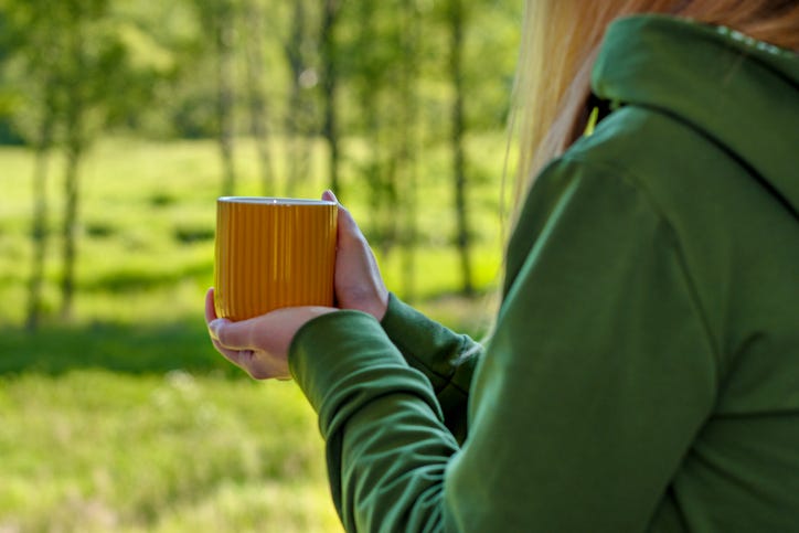 woman drinking coffee weather a hoodie