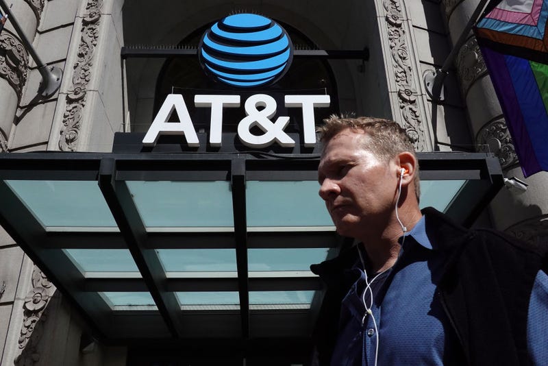 A pedestrian walks by a sign posted in front of an AT&T store on June 20, 2023 in San Francisco, California.