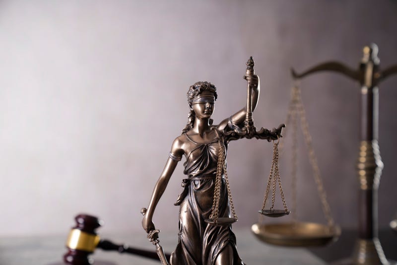 Gavel, scale and Themis sculpture on the gray background.