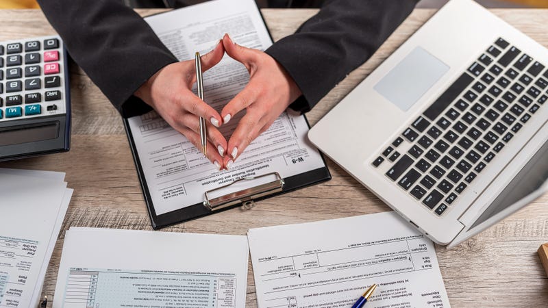 Young woman with computer, tax forms