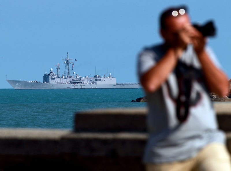 A man snaps pictures at Chicago's Navy Pier as the USS DeWert cruises offshore in Lake Michigan on Aug. 14, 2012. The Oliver Hazard Perry-class frigate was in town for Navy Week and to help commemorate the 200th anniversary of the War of 1812.