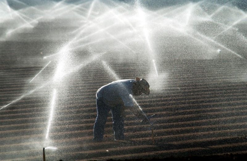 A farm worker adjusts sprinkler heads spraying water that comes from the Colorado River October 18, 2002 near El Centro, California.