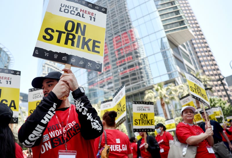 workers with picket signs that say unite here local 11 on strike